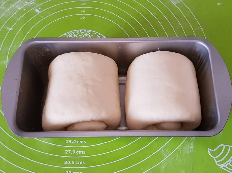 roll both the piece and place in greased loaf tin.