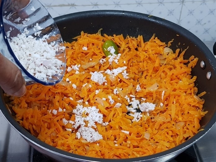 add grated coconut to the stir fried carrot
