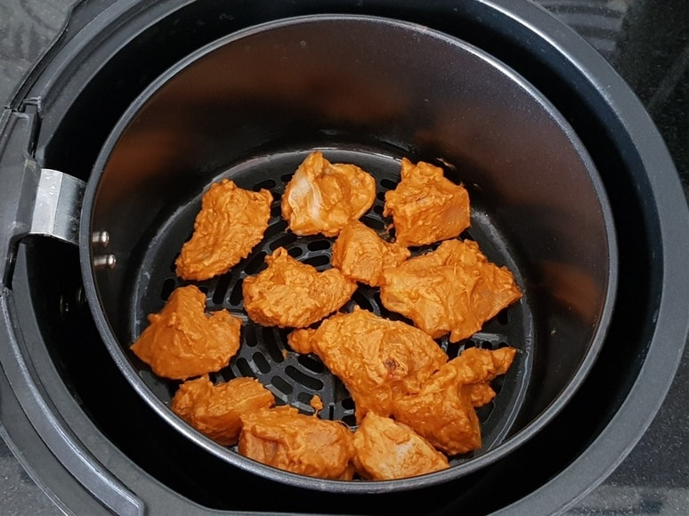 place the chicken pieces on the air fryer basket and cook it for 15 minutes.