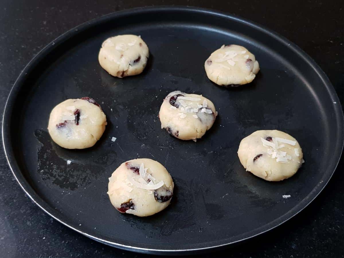 Coconut cranberry cookie dough shaped and slightly flattened before baking.
