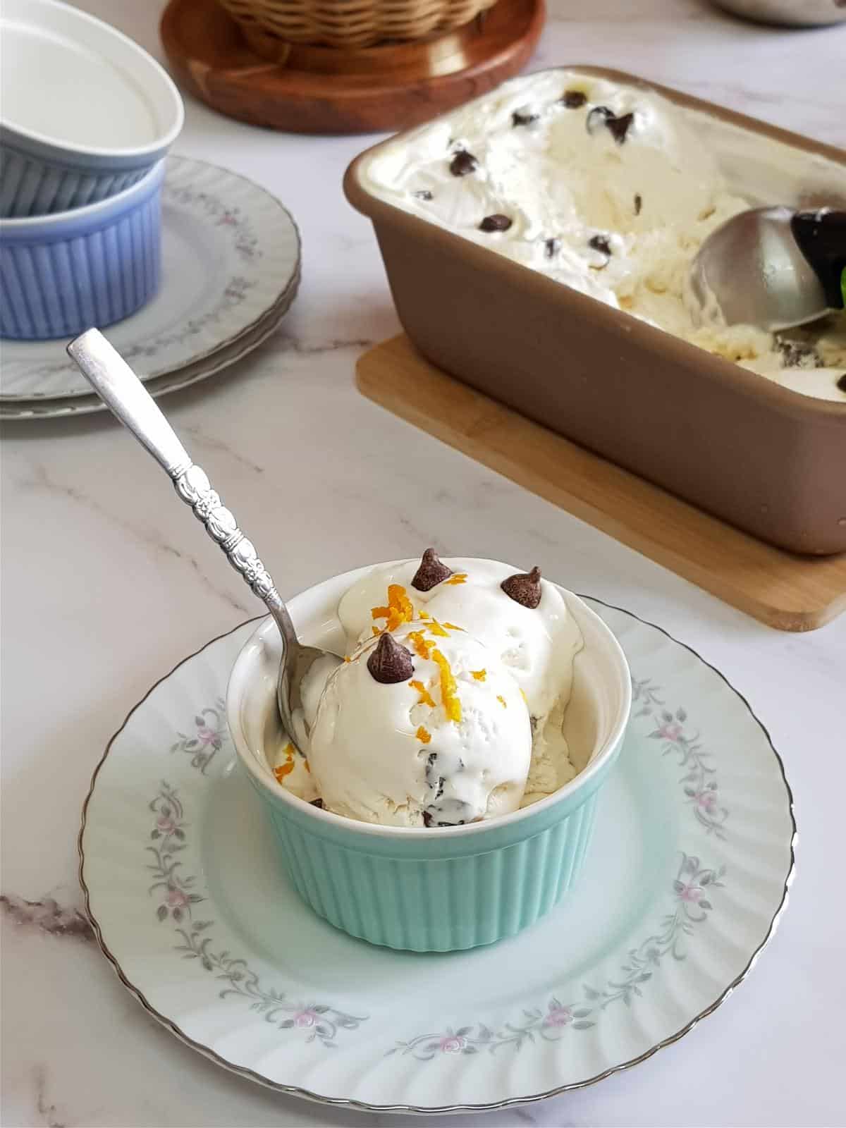 Orange ice cream with dark chocolate chips in a bowl.