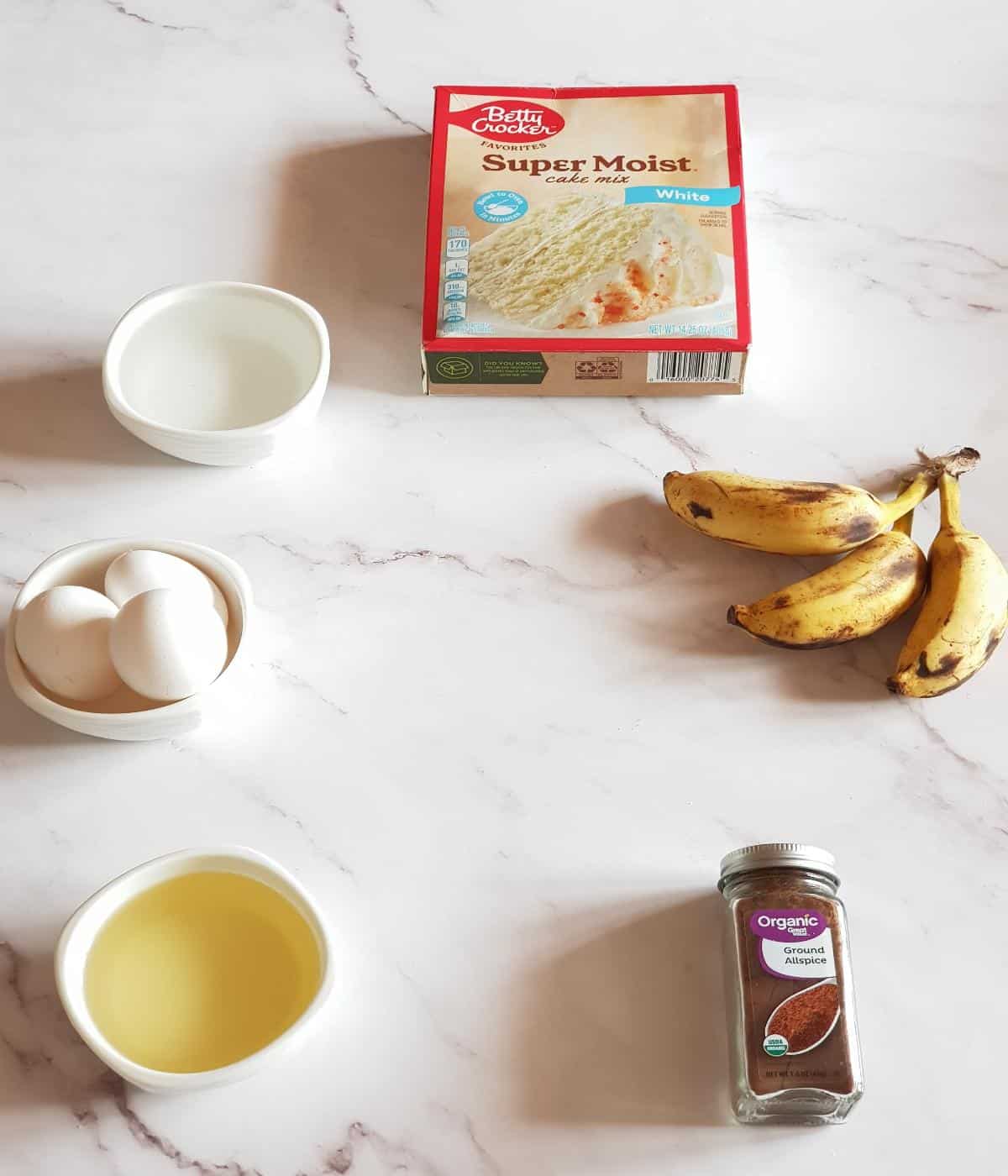 Ingredients for banana cake with cake mix including bananas, eggs, oil, water and allspice.