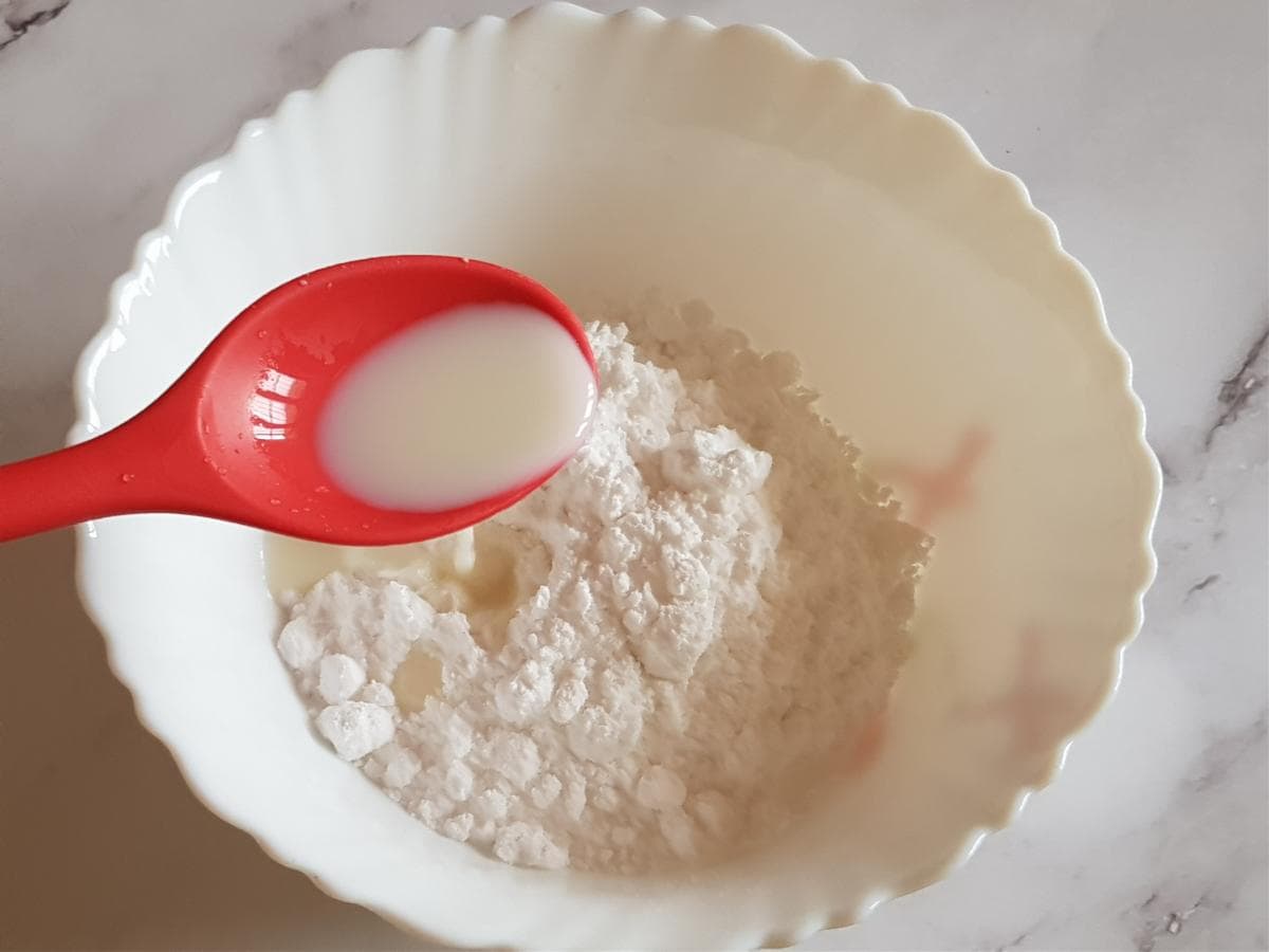 Add milk to the powdered sugar for the cake glaze.