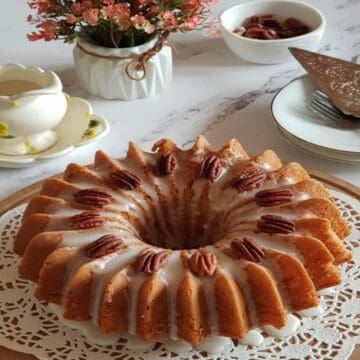 Easy banana cake made with cake mix with vanilla glaze and pecans.