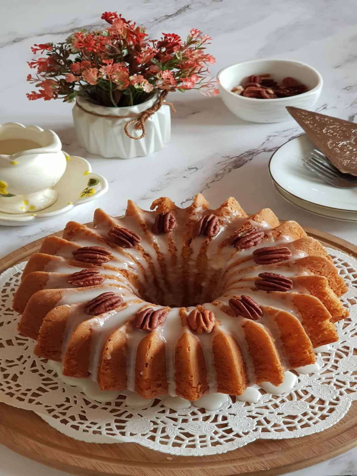 Easy banana cake made with cake mix with vanilla glaze and pecans.